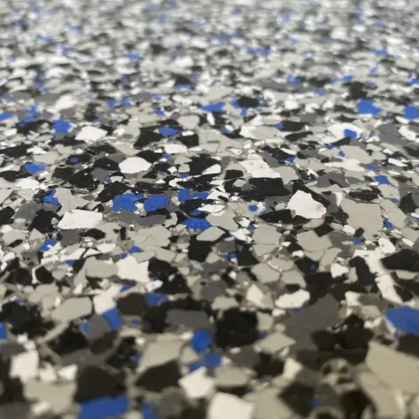 Close-up of a speckled surface featuring scattered black, white, blue, and gray flakes, creating a textured appearance with no visible landmarks or historical buildings.